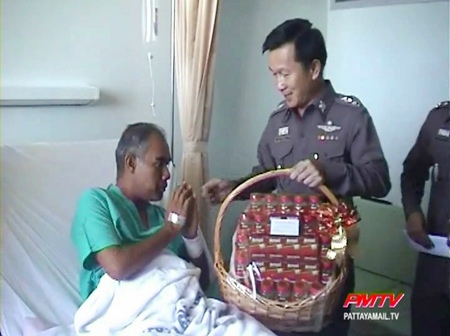 Injured police senior sergeant major Thatpong Thongthat receives a gift from Chonburi Provincial Police Maj. Gen. Thanet Pinmuangam